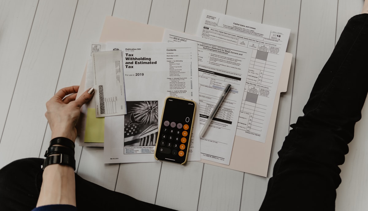 Financial documents and calculator used for net operating income analysis in real estate investing